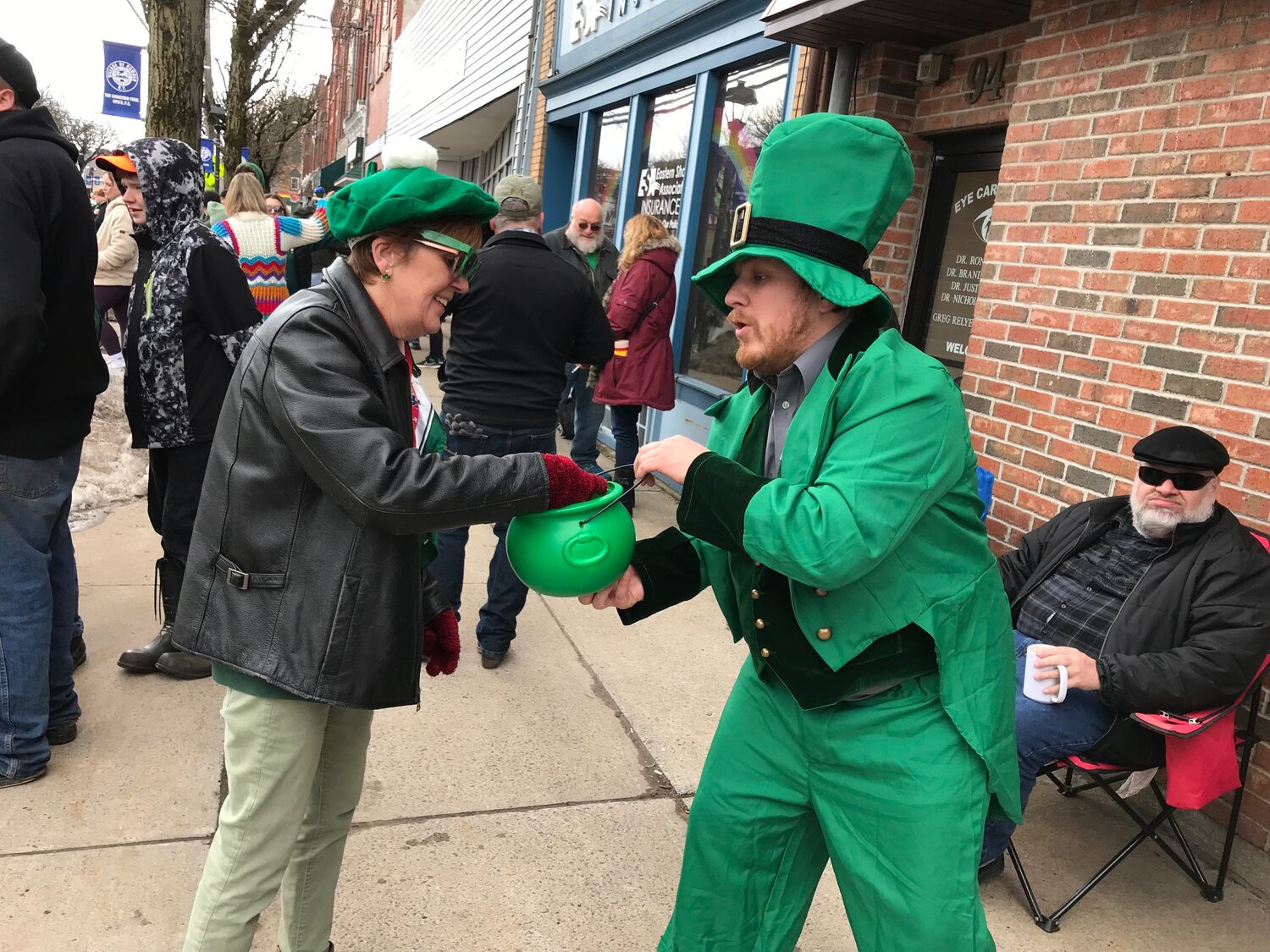 Camden resident Melissa Demeyers, left, reaches into the pot of gold offered by Camden VFW Post 6530 member-turned leprechaun Kris Hummel Saturday, March 18 during the Camden NY Irish Parade.