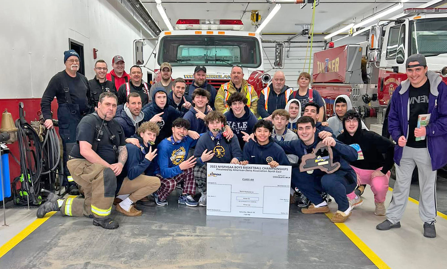 The members of the Section AA state basketball championship team from Victor pose with the Westmoreland Fire Department after their bus got caught in Sunday afternoon’s snow squall on the Thruway. Fire officials said they opened their fire station for the players to wait for a replacement bus to complete the journey home.