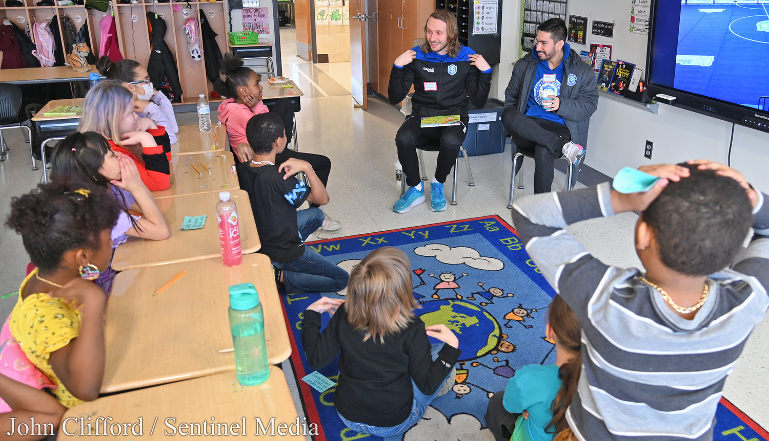 Utica City Football player Timmy Goldman plays "Simon Says" with the 3rd grade class of Jordan Penc before reading the book "Game Time" during the Community Reader's Day event at Kernan Elementary School Friday morning. Helping him is teammate Rafa Godoi.