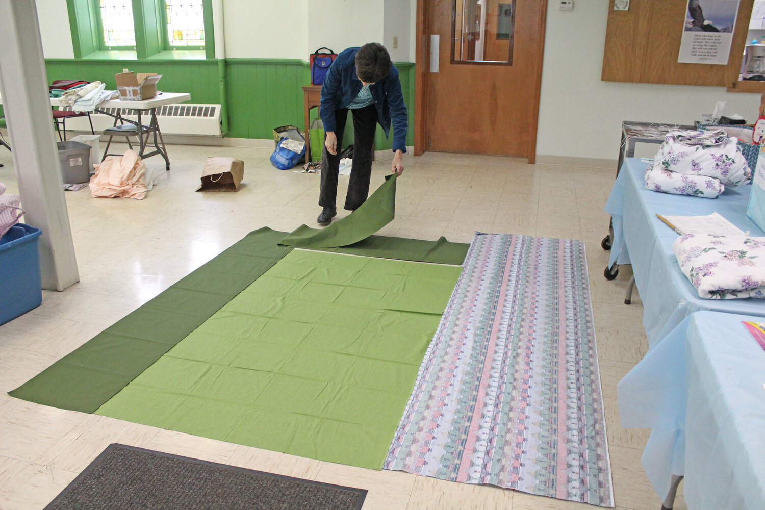 Markings on the floor at Dryden United Methodist Church help measure the fabric to create the sleeping bags' outer layers.