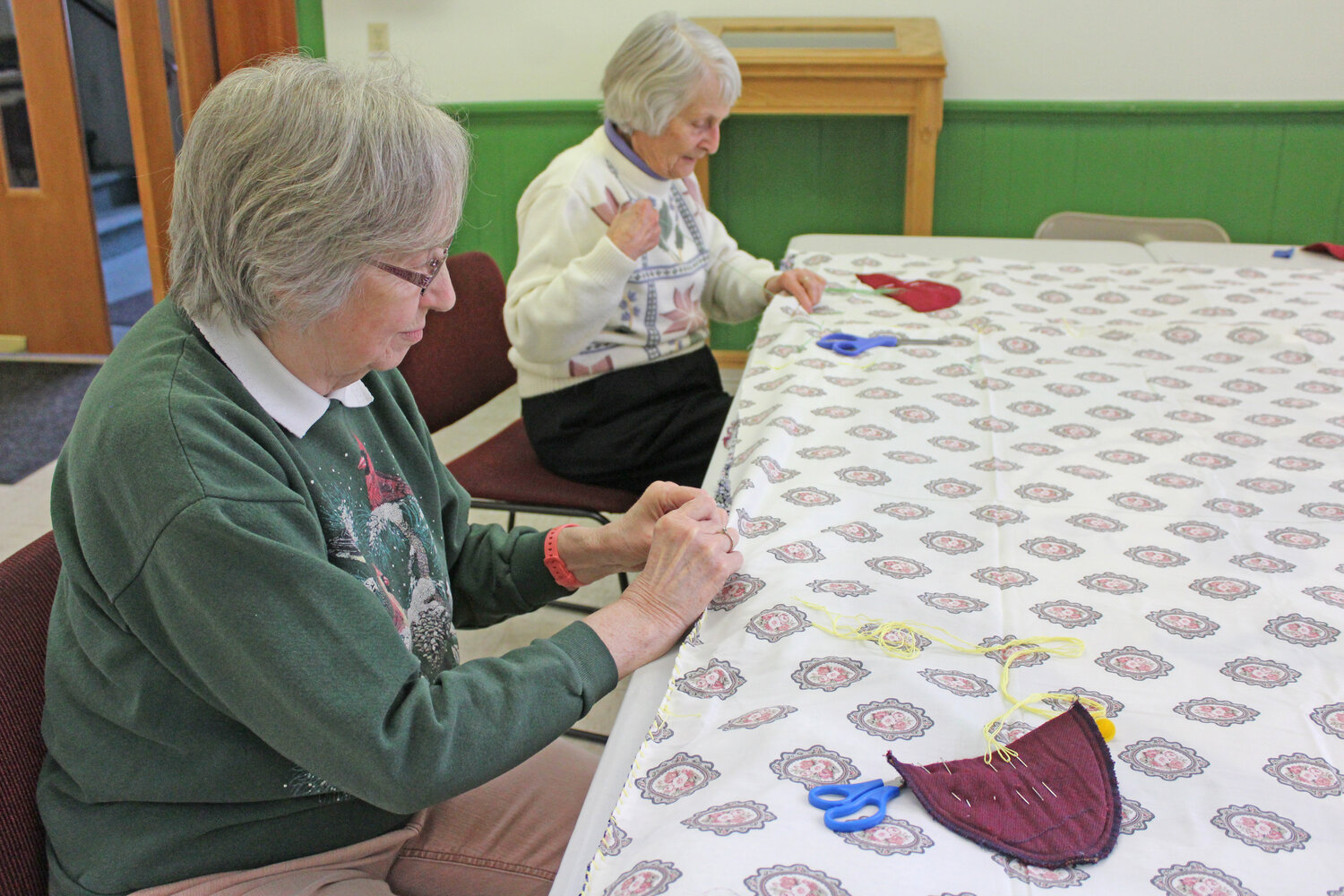 Doreen Dineen of Freeville, left, and Jeanne Lange of Dryden work together to stitch a sleeping bag.