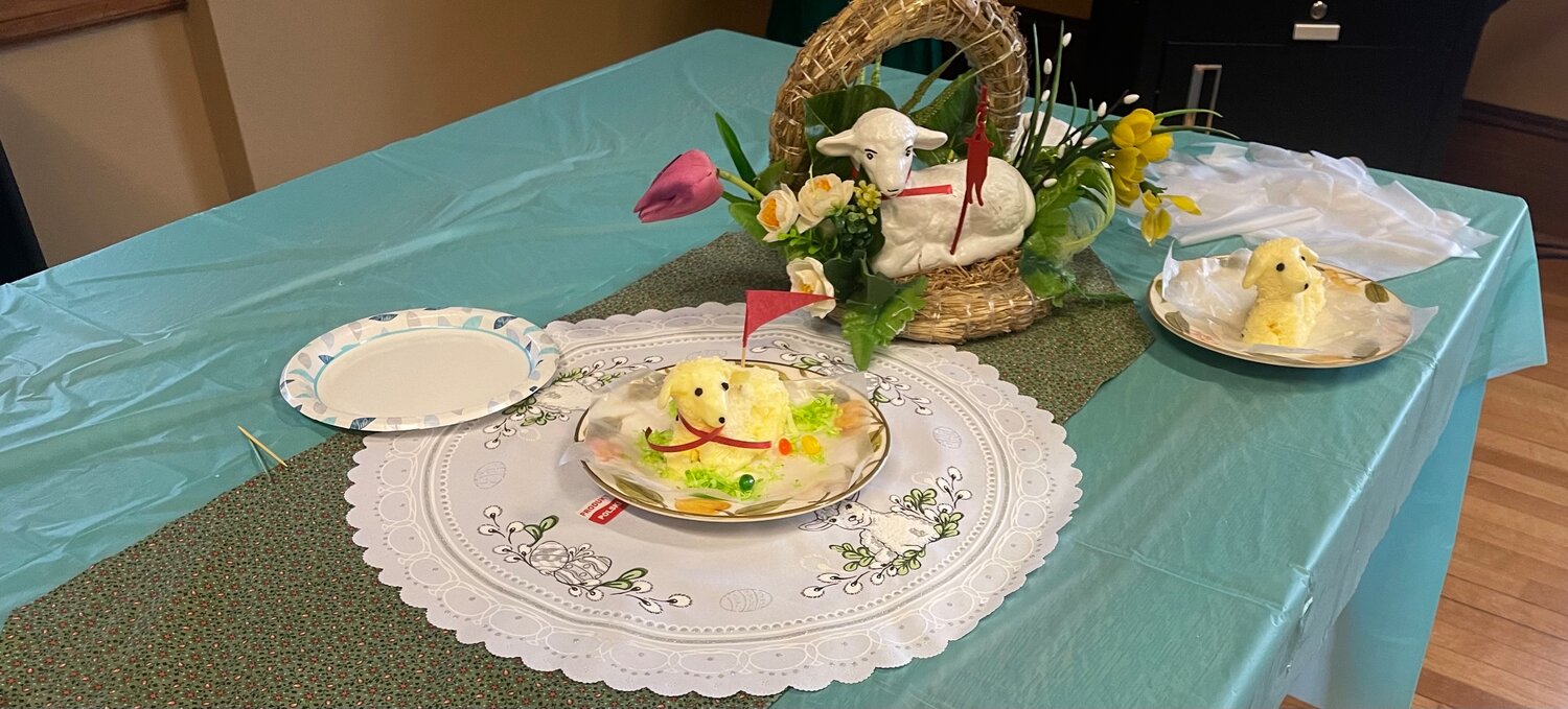 A model butter lamb is complete with red ribbon, flag, fake grass and jelly beans. The butter lamb is a slavic Catholic tradition.