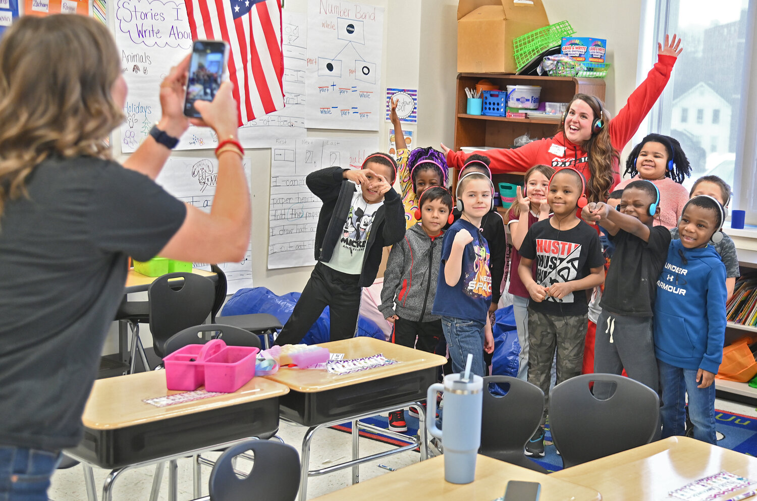 Teacher Jordyn Dunlap, left, gets a photo of Liz Ellis from Kiss FM with her class after the radio personality read a book to her class Friday, March 24 at Kernan Elementary School in Utica.