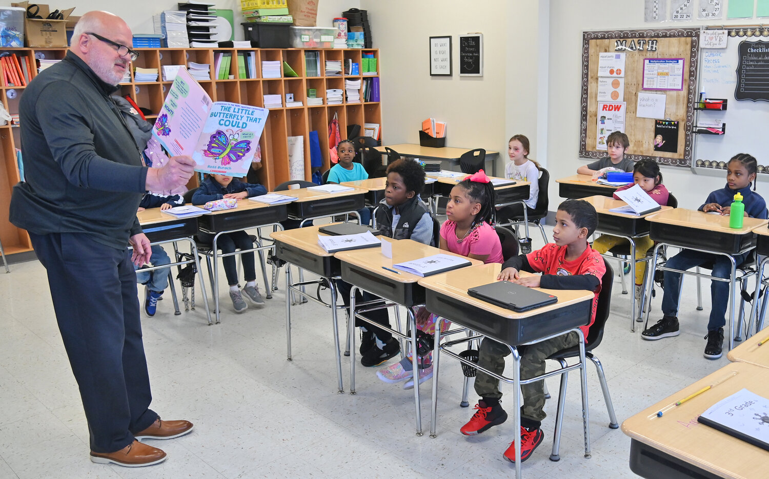Acting superintendent Brian Nolan reads "The Little Butterfly that Could" to Doris Testa's third grade class Friday, March 24 during the Community Reader's Day event at Kernan Elementary School in Utica.