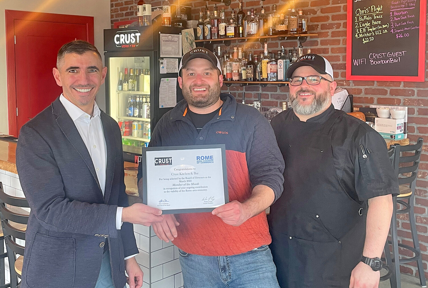 Rome Area Chamber of Commerce First Vice Chairman Greg Mattacola, left, of Strategic Financial Services, presents Crust Kitchen & Bar an award as the chamber’s March Member of the Month. Crust, 86 Hangar Road West, Suite 101 in Air City Lofts on the Griffiss Business and Technology Park at 86 Hangar Road West, seeks “to craft remarkable food and experiences for our remarkable patrons and community.” Receiving the award are Crust co-owners Chris Destito and Frank Belmont.