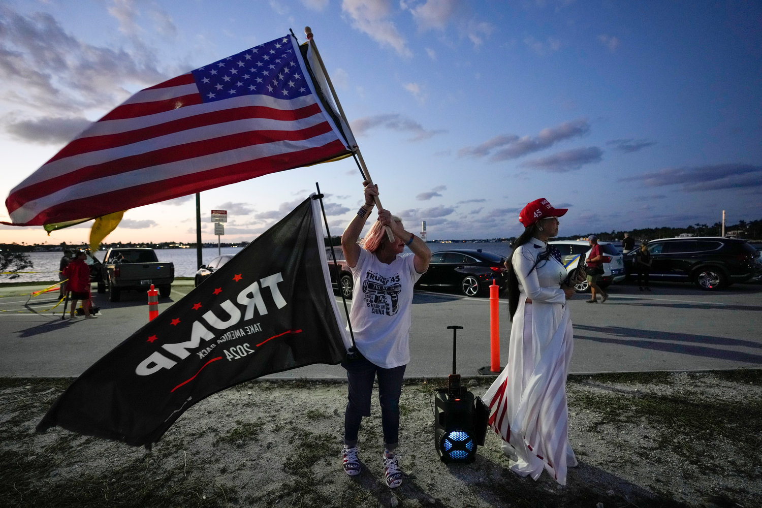 Trang Le of Orlando, right, and Maria Korynsel of North Palm Beach show their support for former President Donald Trump after the news broke that Trump has been indicted by a Manhattan grand jury, Thursday, March 30, 2023, near Trump's Mar-a-Lago estate in Palm Beach, Fla.