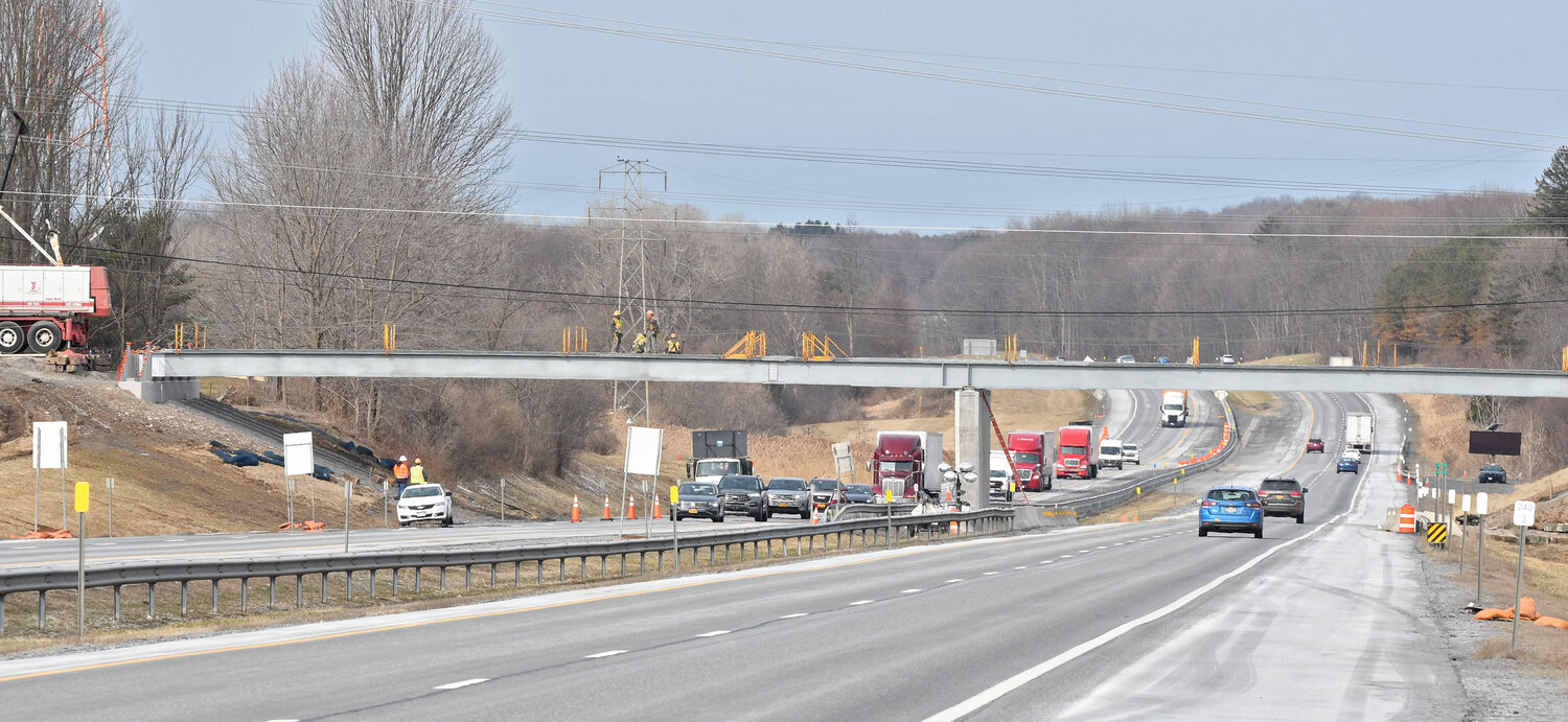 Members of a construction crew help to install massive steel beams on the Route 840 bridge over the New York State Thruway in this photo captured on Friday, March 31.  The bridge, which was shut down in May 2022, is expected to see construction of the new span completed by later this spring, according to officials with the Thruway Authority.