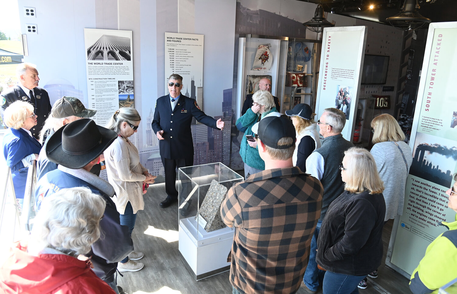 Retired NYC fireman Robert Reeg, who survived the injuries suffered when the towers collapsed on 9/11, gives a tour of the artifacts Thursday on the opening of the 9/11 Never Forget Mobile Exhibit at the Griffiss Business and Technology Park.
