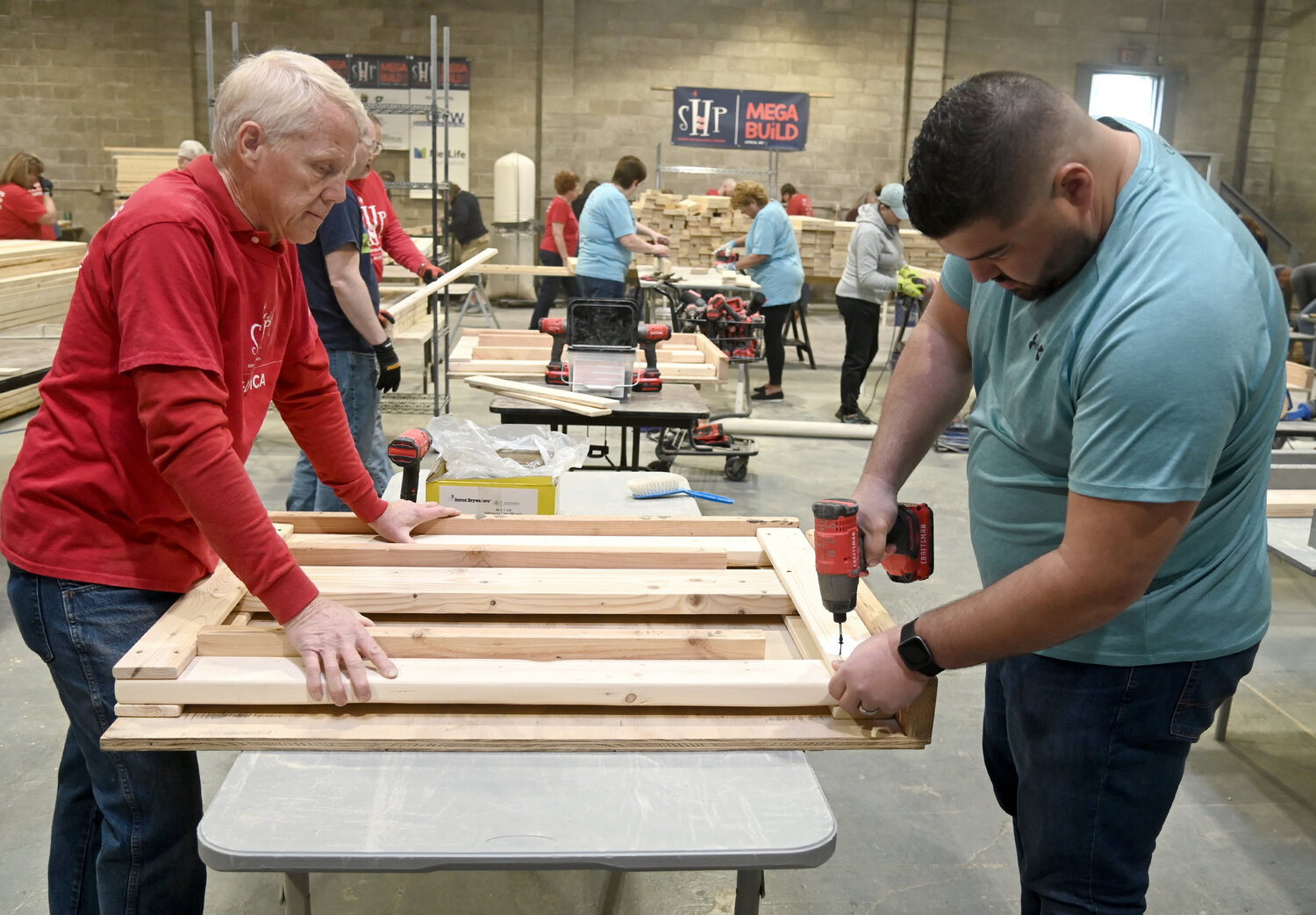 Dave Husted and Rich Hickel build headboards at the SHP Mega Build II event in Yorkville on Friday afternoon.