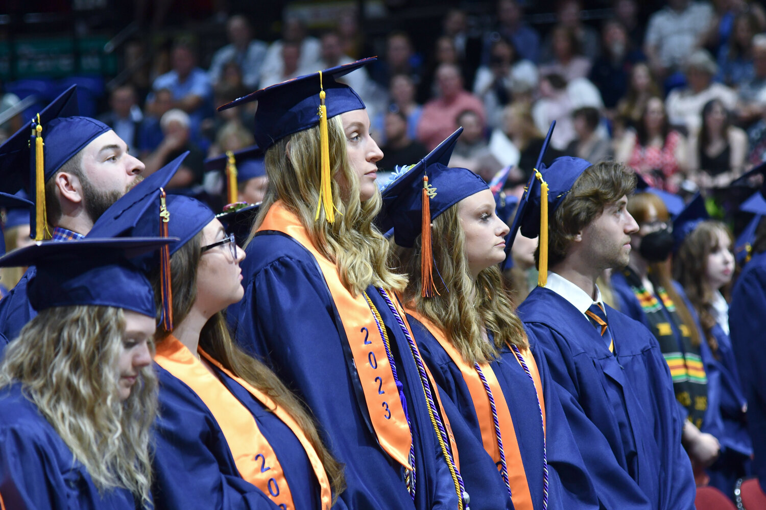 Students stand and look on as Utica University's 74th undergraduate commencement ceremony takes place.