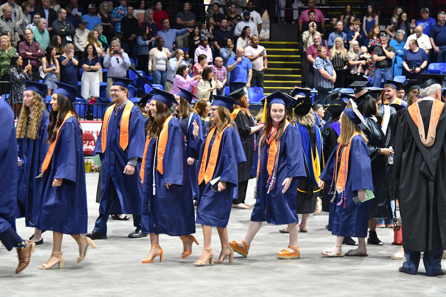 Students look around to see the crowd of people in attendance as they walk to their seats during Utica University's 74th undergraduate commencement.