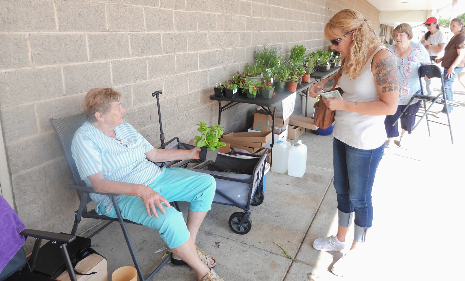 Mabel Smith, a member of the Green Thumb Garden Club of Oneida Castle, talks to a customer at the garden sale on Friday, May 12 before making a sale.