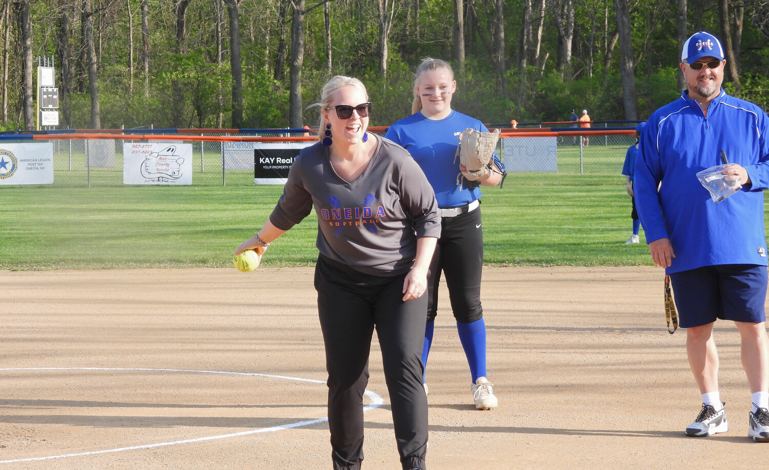 Worthy Owner Jennifer Bailey throws out the ceremonial first pitch for an Oneida Girl's Little League Softball game on Thursday, May 11 at Maxwell Field in Oneida. Pictured alongside Bailey throwing the first pitch is Oneida Girl's Little League Softball Commissioner Nick Fedchenko and Pitcher Karalynne Camron, 12.
