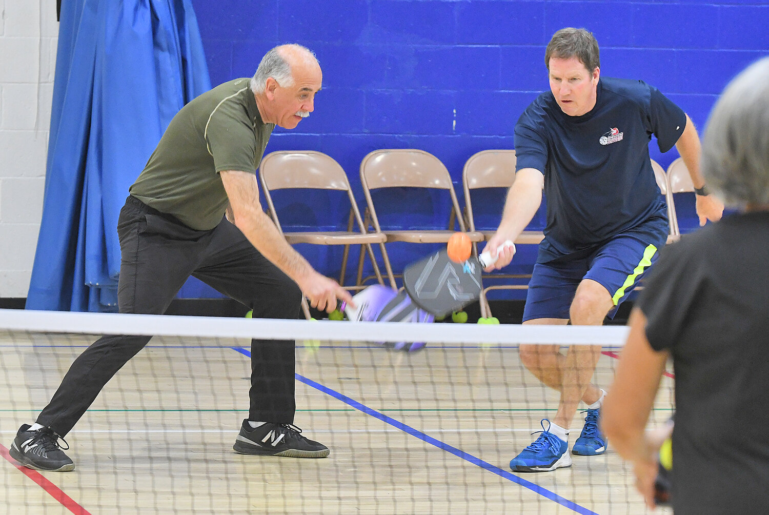 Dave Meislin (left) makes a return during pickleball play Thursday evening at the Jewish Community Center with Jamie King.
