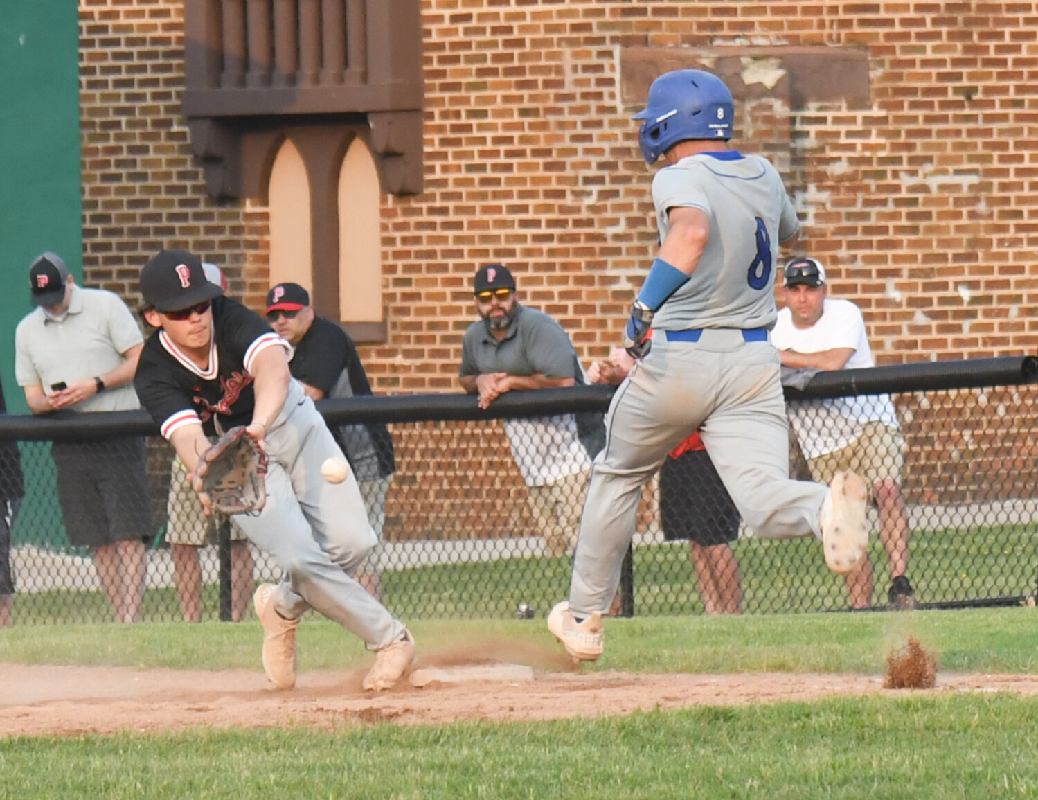A Proctor player tries to field a throw as Cicero-North Syracuse's Carter King runs to first base on Tuesday in the Section III Class AA quarterfinal game at Murnane Field in Utica. CNS won 12-7.