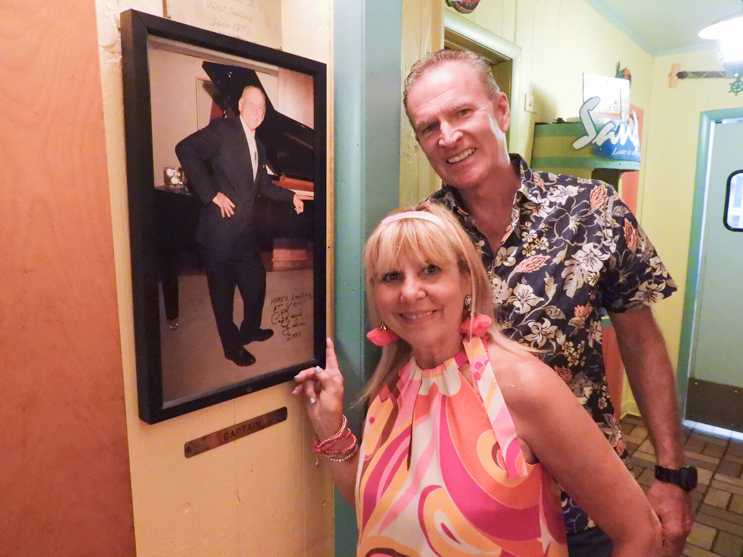 Elaine DePerno-Brown, daughter of the original Captain John, and her husband Andy Brown run a tight ship at Captain John’s. Pictured are the two standing by a picture of the original Captain John.