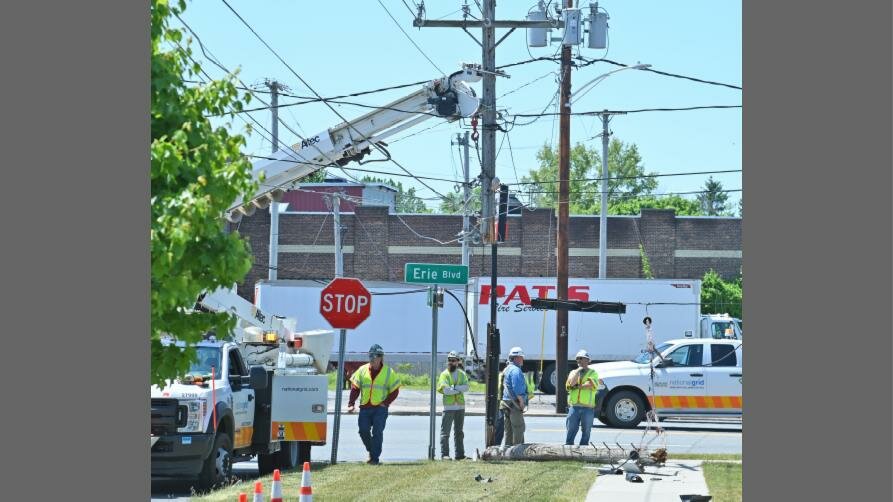 National Grid workers survey the scene after using a boom truck to secure the top portion of a utility pole while the bottom portion of the pole lays on the ground at the corner of Erie Blvd. West and and South Jay Street, near the Stewart’s Shop on Friday, May 26. The pole was toppled by a Stewart’s truck, forcing westbound traffic on Erie Blvd West to be diverted. The eastbound lanes were still in use.  Workers remained on the scene with plans to install a replacement pole.