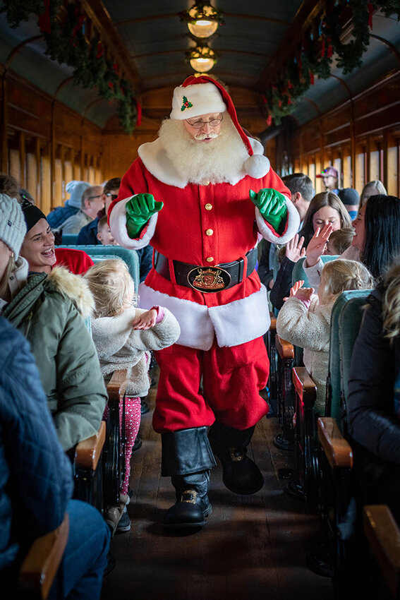 Santa Claus high-fived guests aboard the Strasburg Railroad Christmas trains.