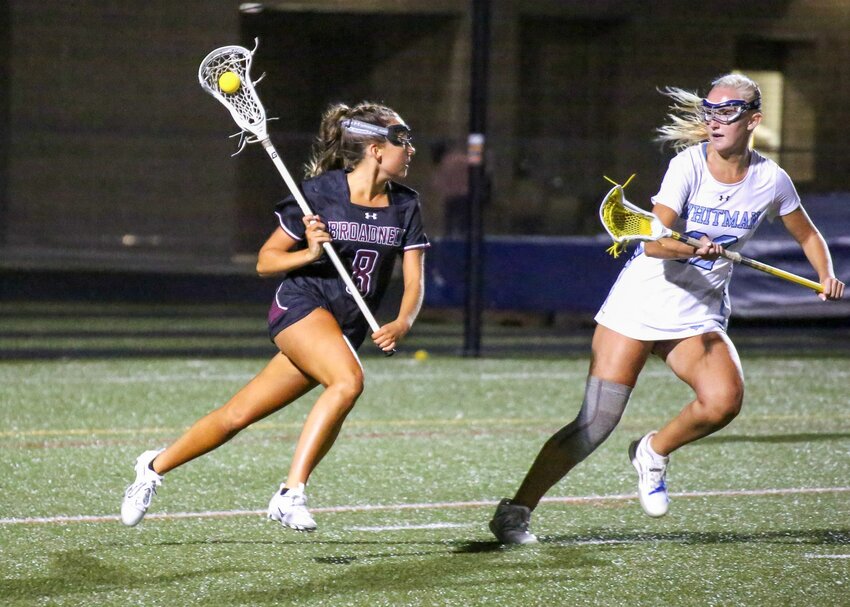 Cayman Holmes (8) looked for a passing option during Friday’s girls lacrosse state semifinal game.