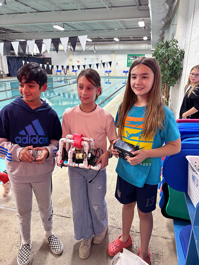 Folger McKinsey students Aidyn, Lucia and Maggie posed with their SeaPerch vessel, the U.V. Minnow, at Severna Park Fitness and Racquetball Club, where the teams prepared to test their robots.