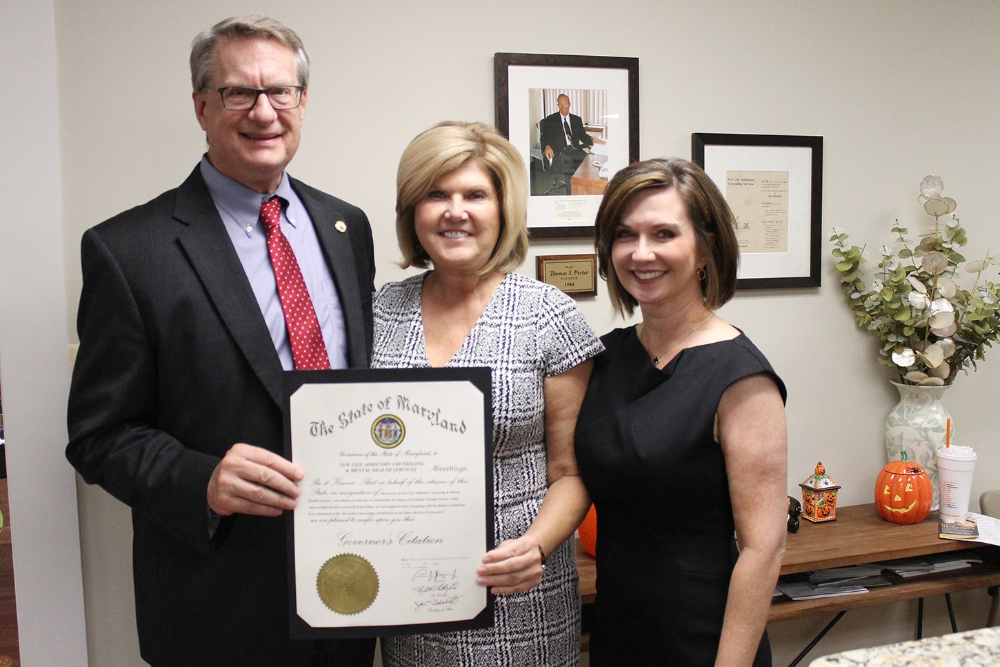 (L-R) Clay Stamp, executive director of Maryland’s Opioid Operational Command Center, presented the award to Porter’s daughters, Beverly Ervin, CEO of New Life Addiction Counseling Services, and Anissa Nahabedian.
