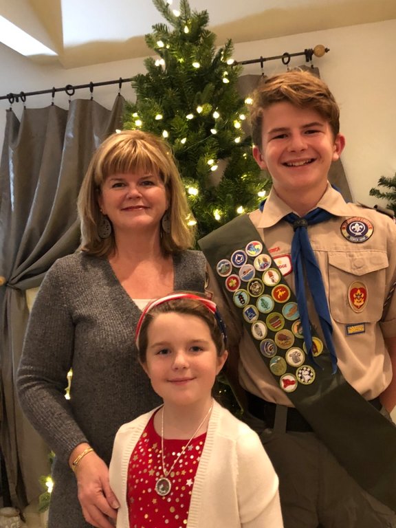 Fletcher Port (right) is trying to achieve the rank of Eagle Scout by building shelves at a USO warehouse and by sending care packages to members of the military. He is pictured with his mom, Amy, and sister, Zoe.