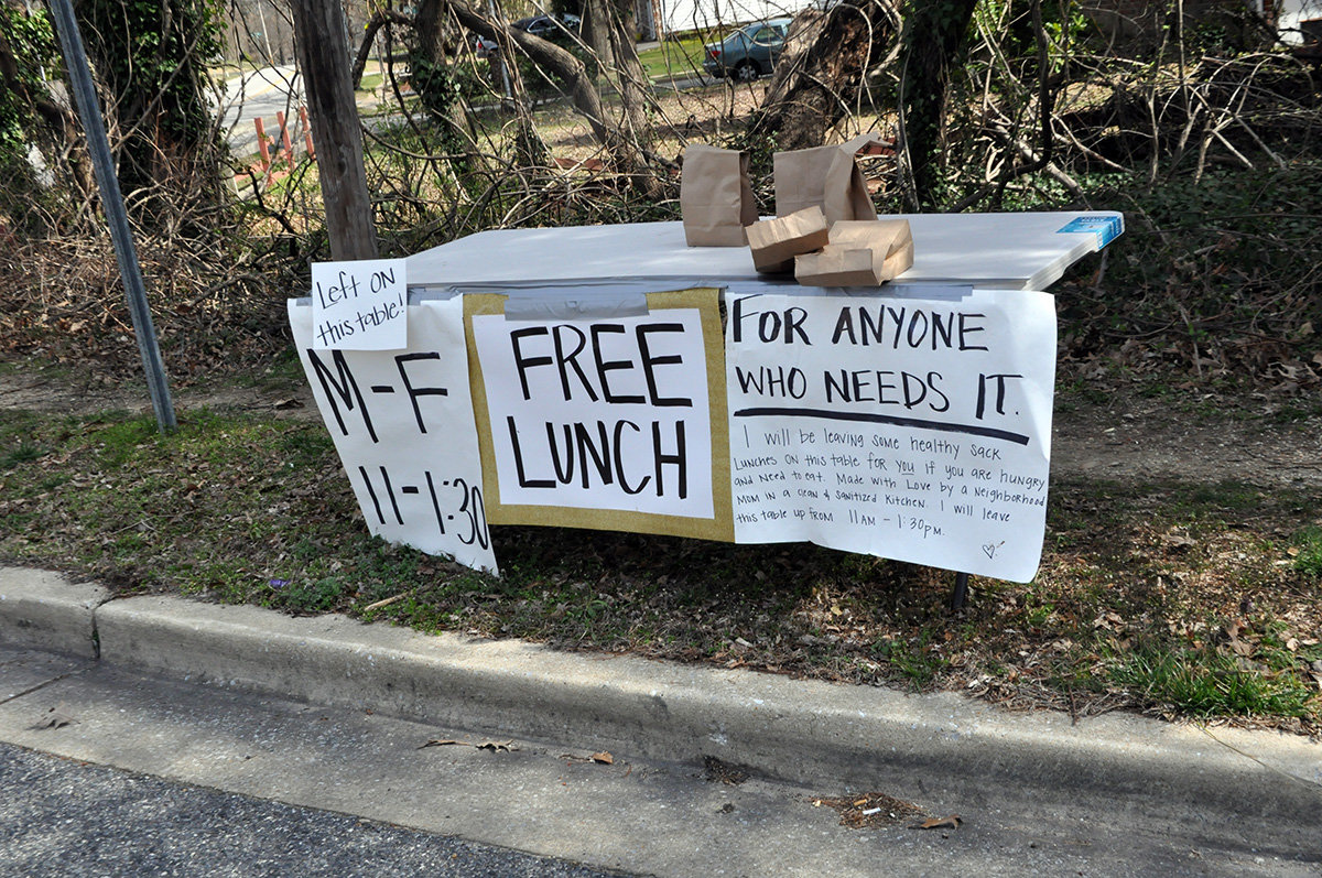 An anonymous neighborhood mom has set up a table with bagged lunches every weekday by the traffic circle on Leelyn Drive.
