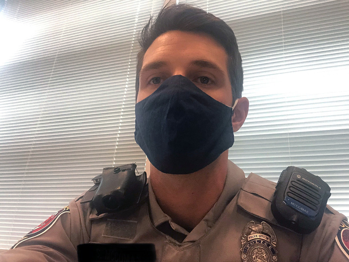Police officer Shane McComas wore one of Lauren Lombardo’s masks at the Arlington Police Department.