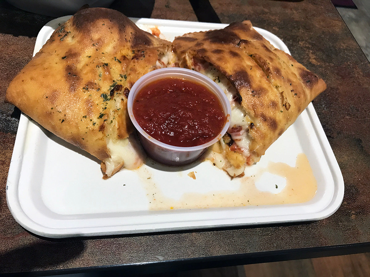 The colossal veggie calzone, stuffed with veggies and cheese, is a pleasing carb-comfy meal.