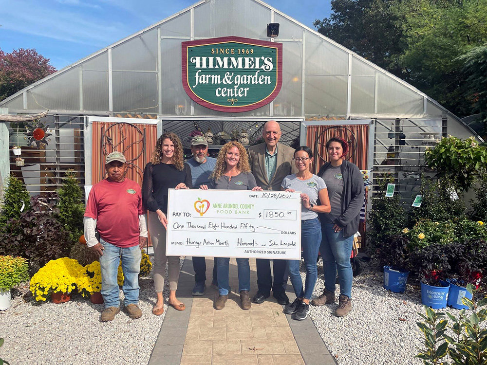 Elizabeth Elliott (center), owner of Himmel’s Landscape & Garden Center, and former county executive John Leopold (third from right) donated a combined $1,850 to the Anne Arundel County Food Bank.