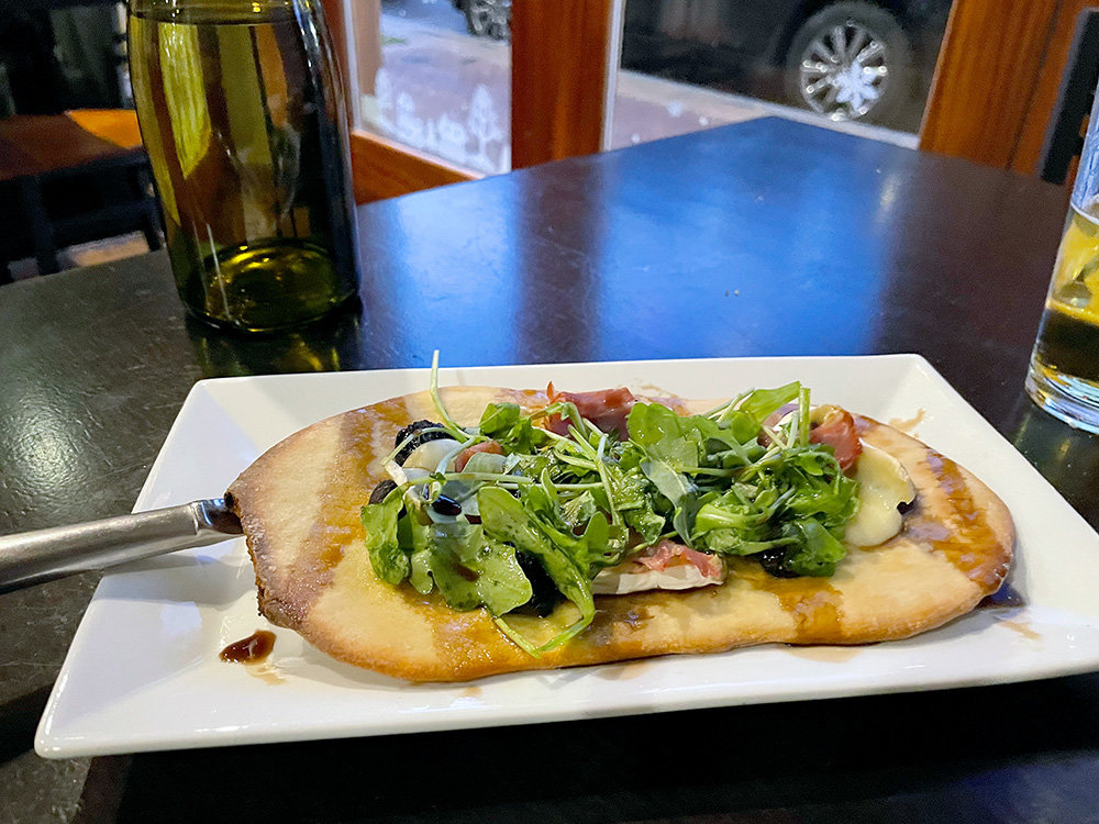 The fig and brie flatbread offers a burst of flavors - sweet figs, savory prosciutto and soft mellow bris - all on toasted flatbread drizzled with balsamic vinegar.