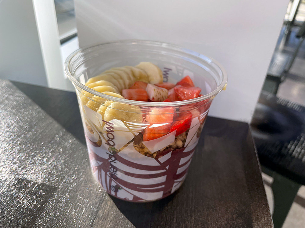 The acai bowl has a base of acai blended with banana and apple juice, topped with granola, bananas and strawberries