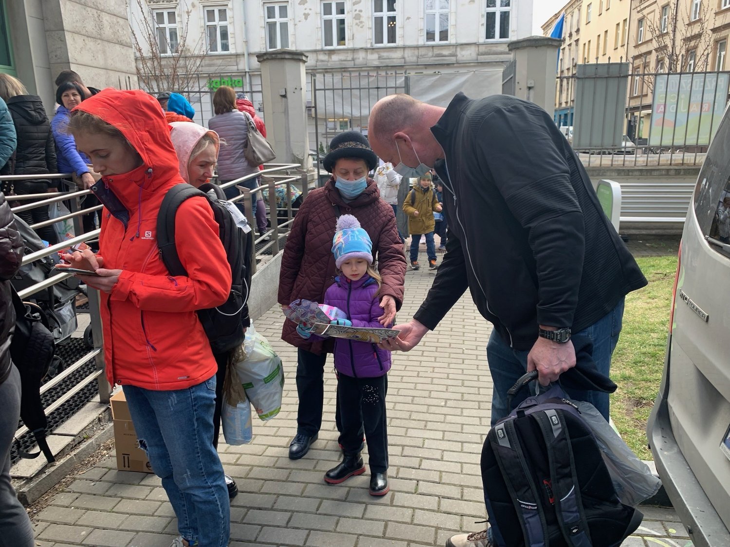 Rabbi Ari Goldstein handed a coloring book to a refugee child arriving at the JCC in Krakow, Poland.