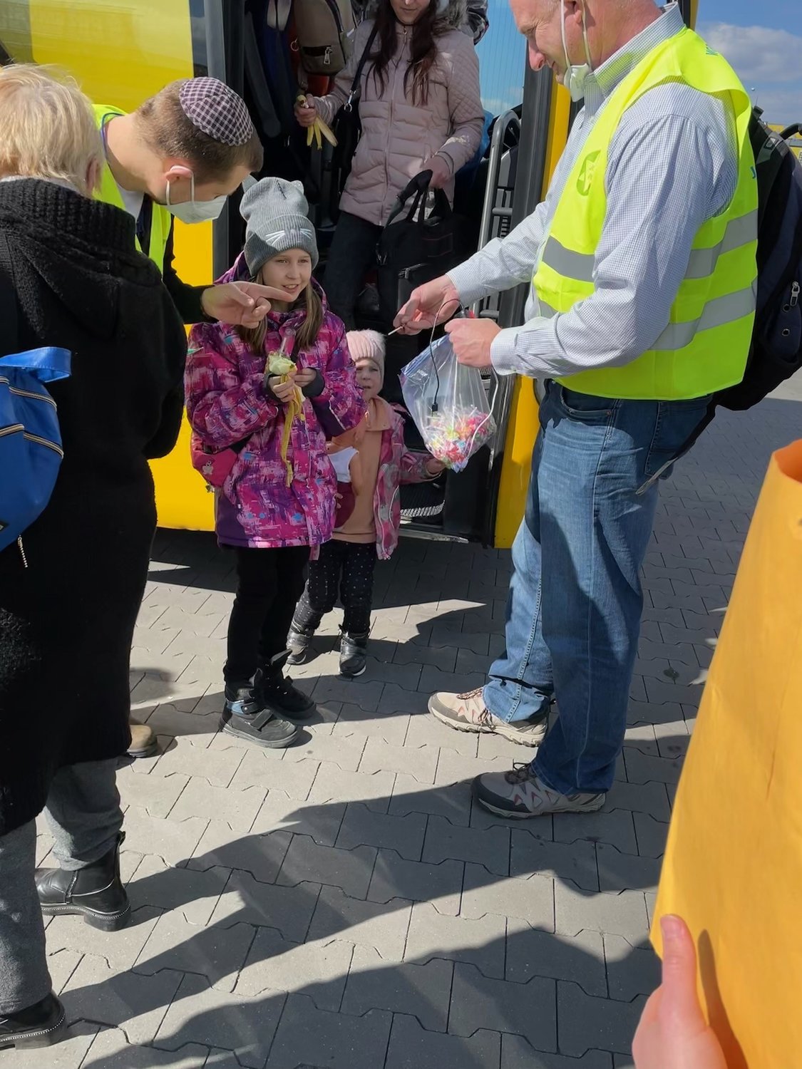 Rabbi Ari Goldstein offered a lollipop to a Ukrainian child arriving at the border town of Przemysl, Poland. Through an interpreter, they were able to assure children that they were trying to help and not harm.