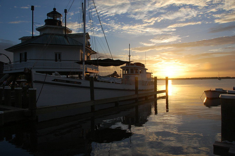 The sun rises over the Miles River with the 1879 Hooper Strait Lighthouse and the 1920 buyboat Winnie Estelle waiting for the day's guests.