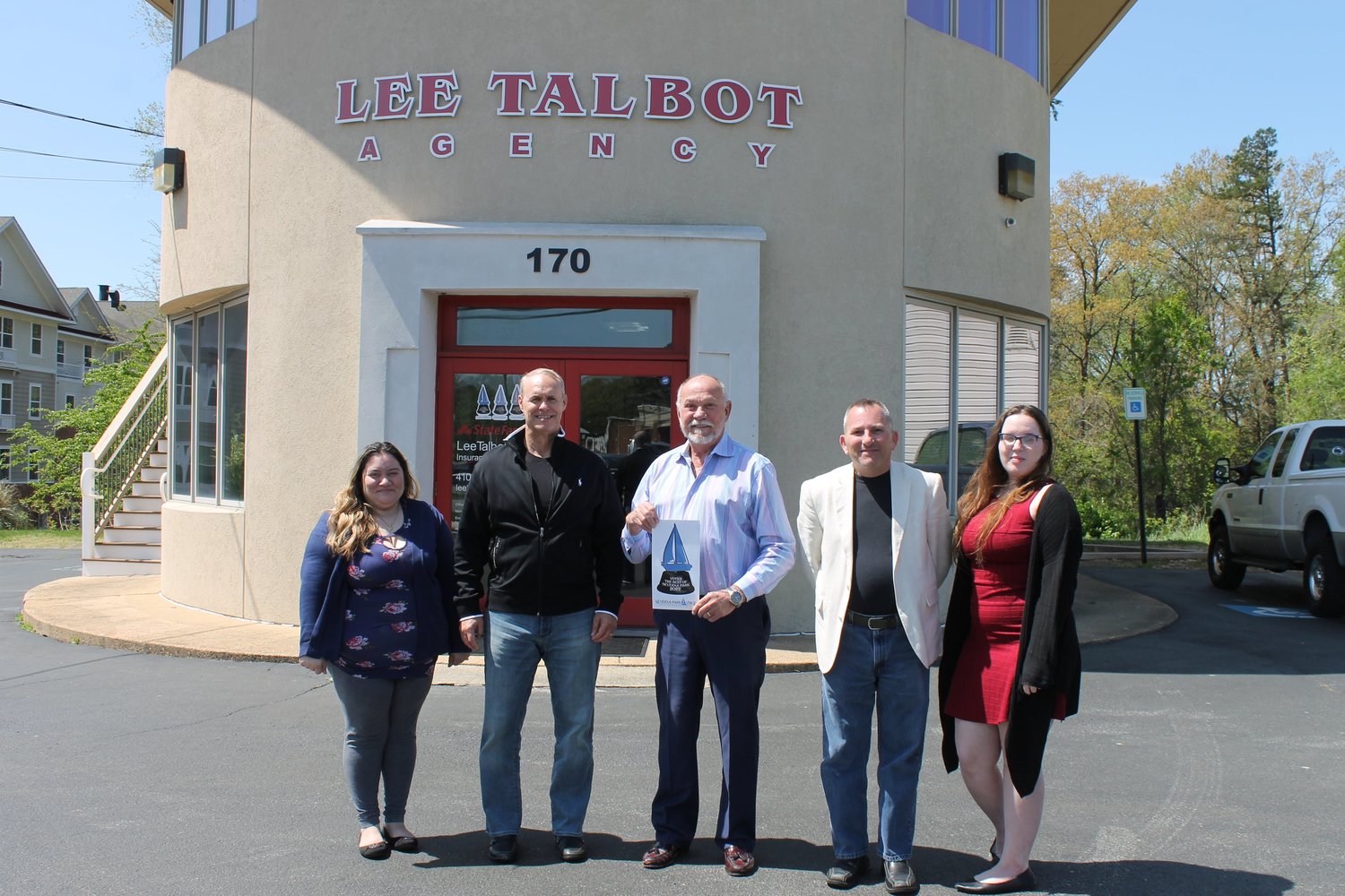 Standing in front of their office, Lee Talbot (center) and his team accepted the honor of Best Insurance Agent.
