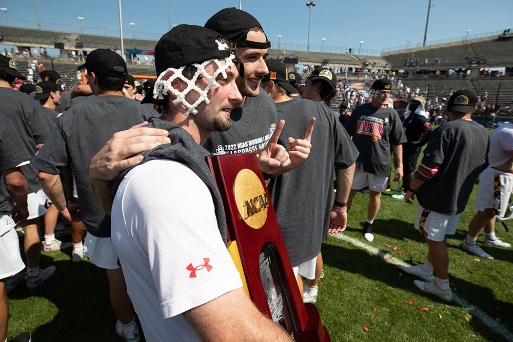 Josh Coffman (in front) posed with a teammate while holding the NCAA men’s lacrosse trophy.