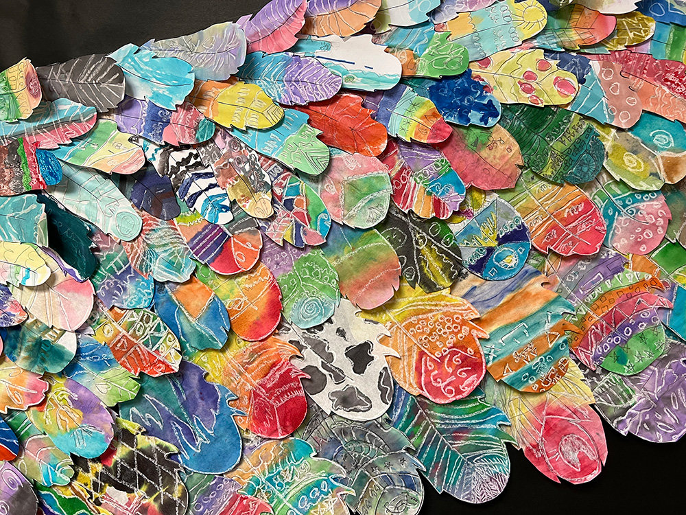 To commemorate the school community’s year together, teacher Christina Young wanted to create something that represented the students as one body. She gave the students feather templates that, when combined, created wings.