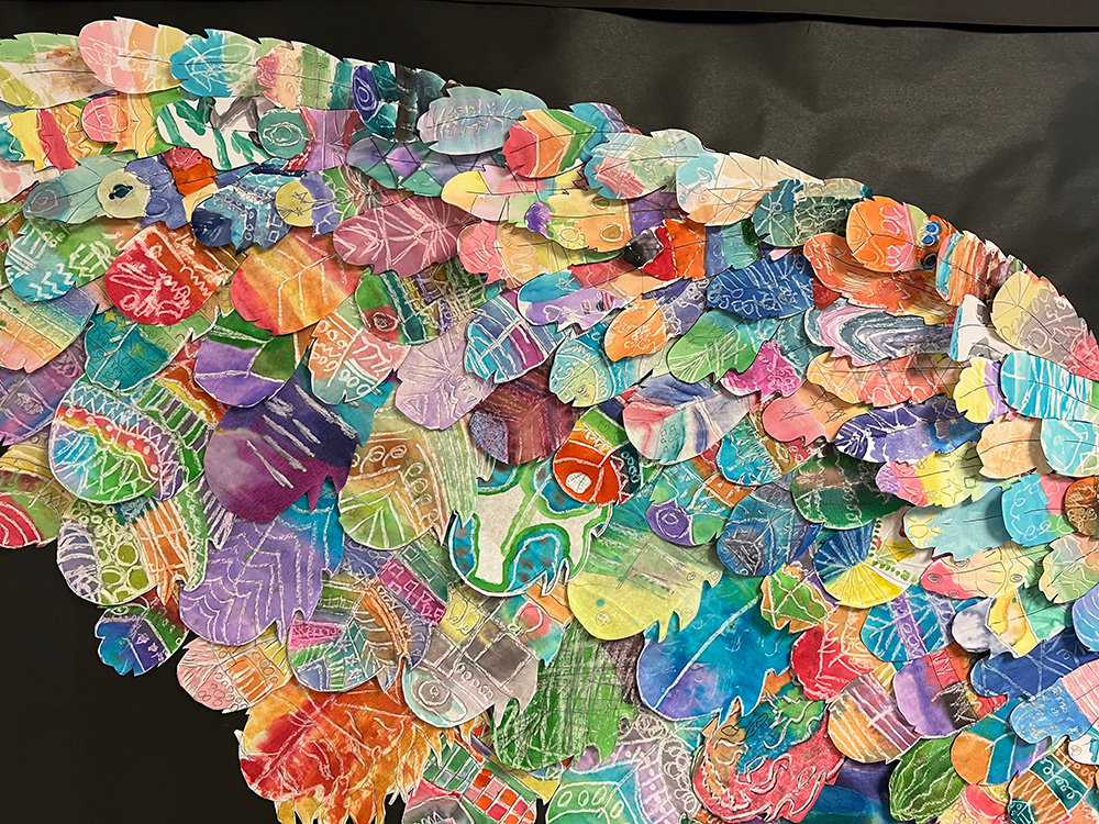 To commemorate the school community’s year together, teacher Christina Young wanted to create something that represented the students as one body. She gave the students feather templates that, when combined, created wings.