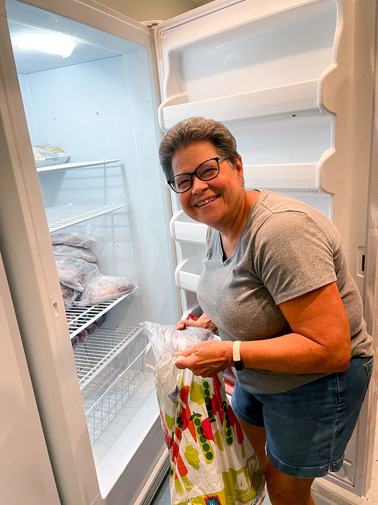 Pantry manager Kathy Middel pulled meat from the pantry freezer.