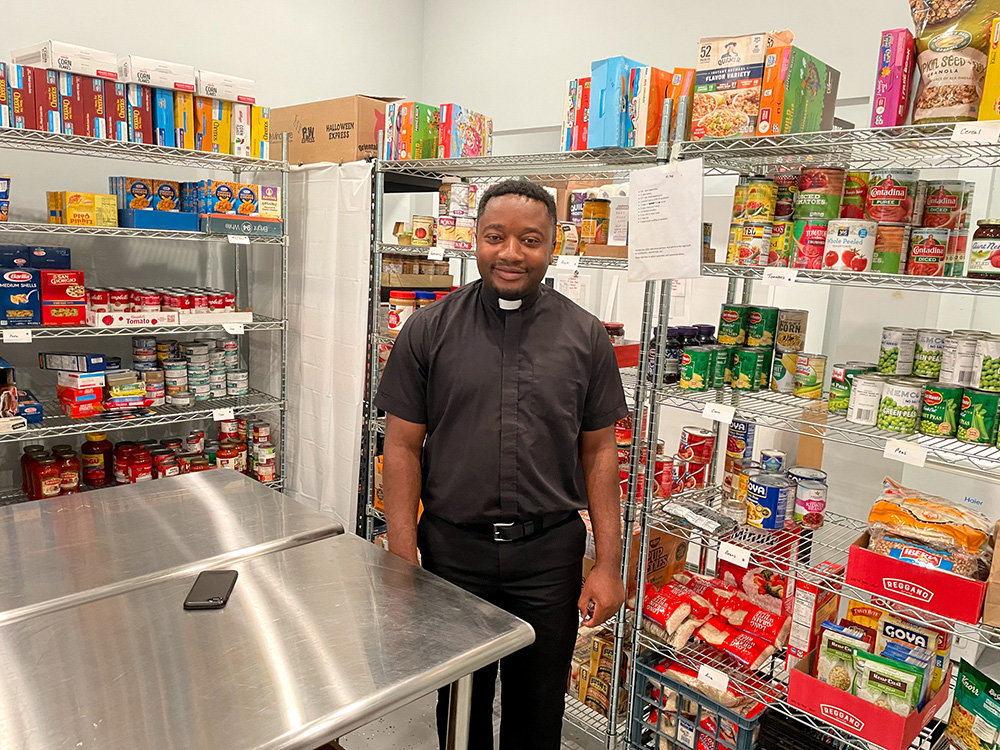 Father Shadrik Mokum, with St. John the Evangelist, provides spiritual support at the pantry.
