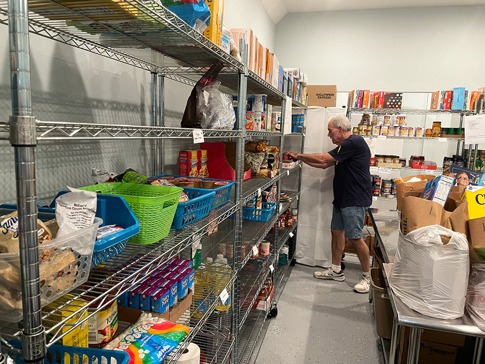 Volunteer Rich Kenny searched the shelves for food items.