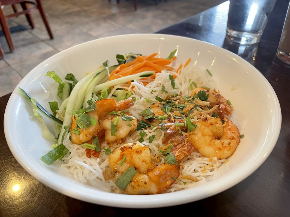 Bun/com offers a choice of noodles or rice. It's like pho, but with fish sauce instead of broth. The dish included lettuce, cucumbers, pickled carrots and radishes, cilantro, fried red onions and tender shrimp. The ingredients make for a sweet and spicy dish.