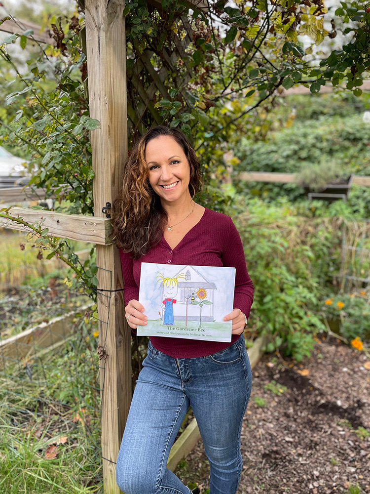 Melissa Wissler stood in her Annapolis garden with her new book, “The Gardener Bee.”