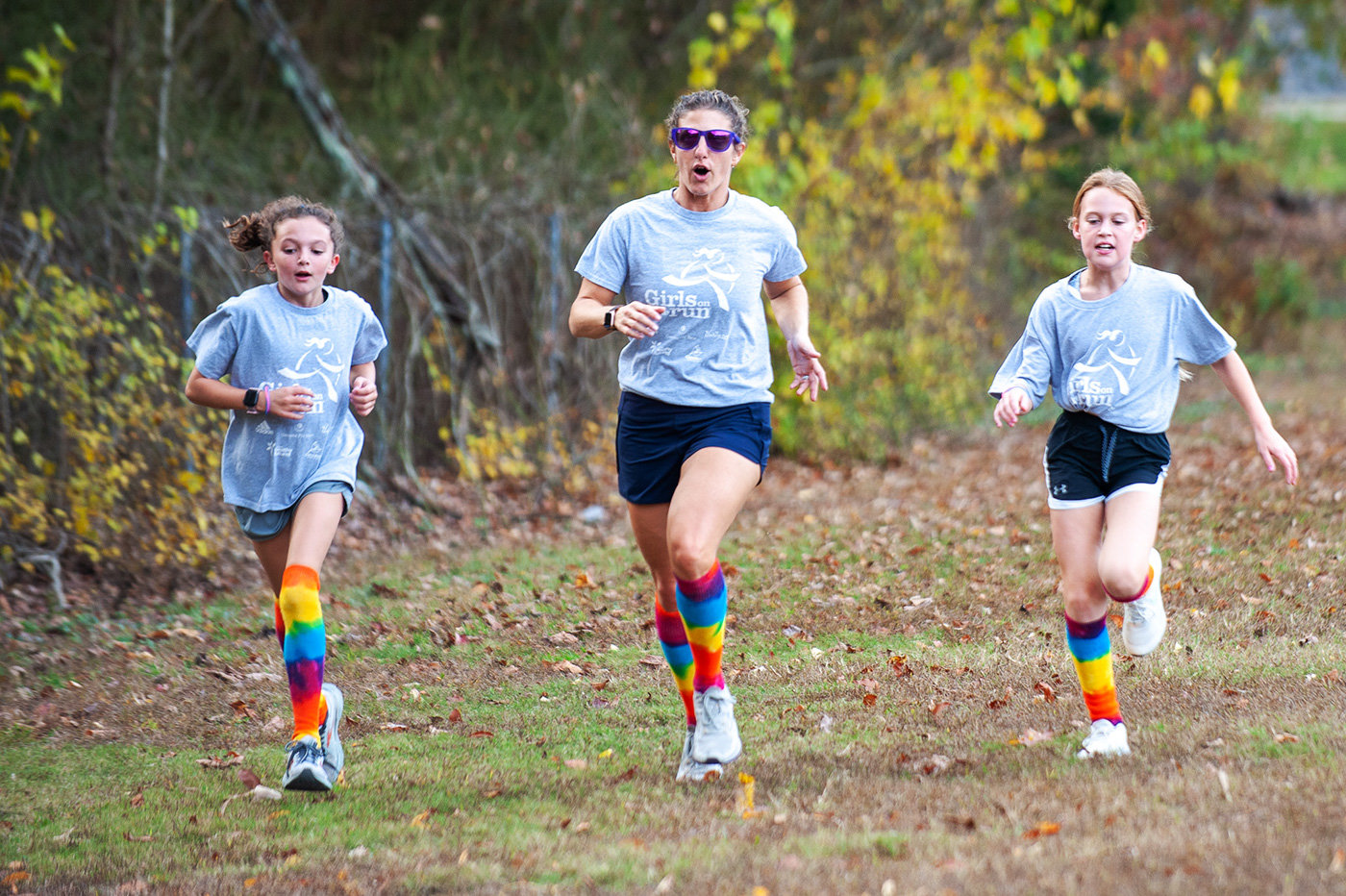 Oak Hill Elementary Girls on the Run head coach Allison Hamilton (center) slowed her pace to offer encouragement to Morgan Hamilton (left) and Claire Crivella.
