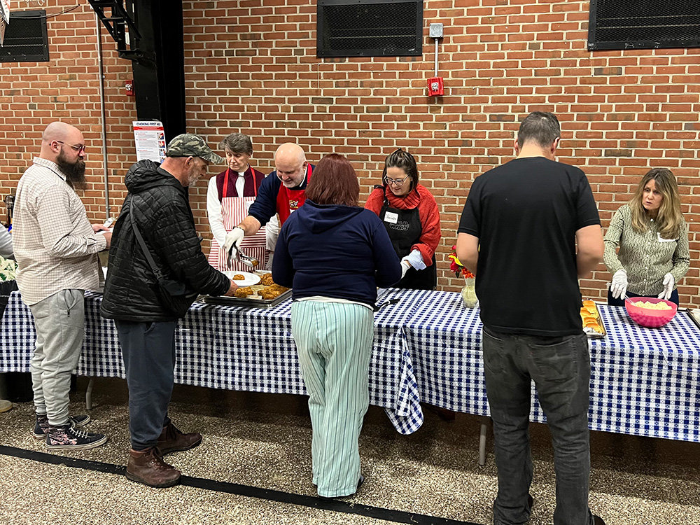 Staff members from St. John the Evangelist Church served guests food during the Arundel House of Hope’s Winter Relief program.