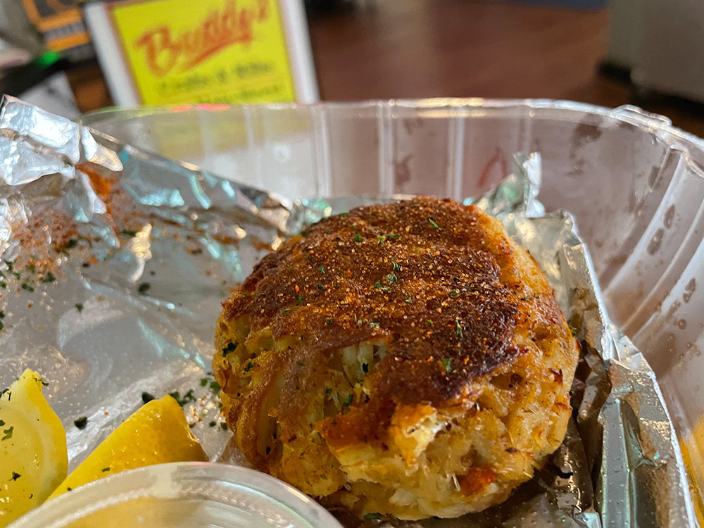 The crab cake from Buddy's is slightly larger than some of its local counterparts. It’s full of lump crab meat, with seasonings on top.