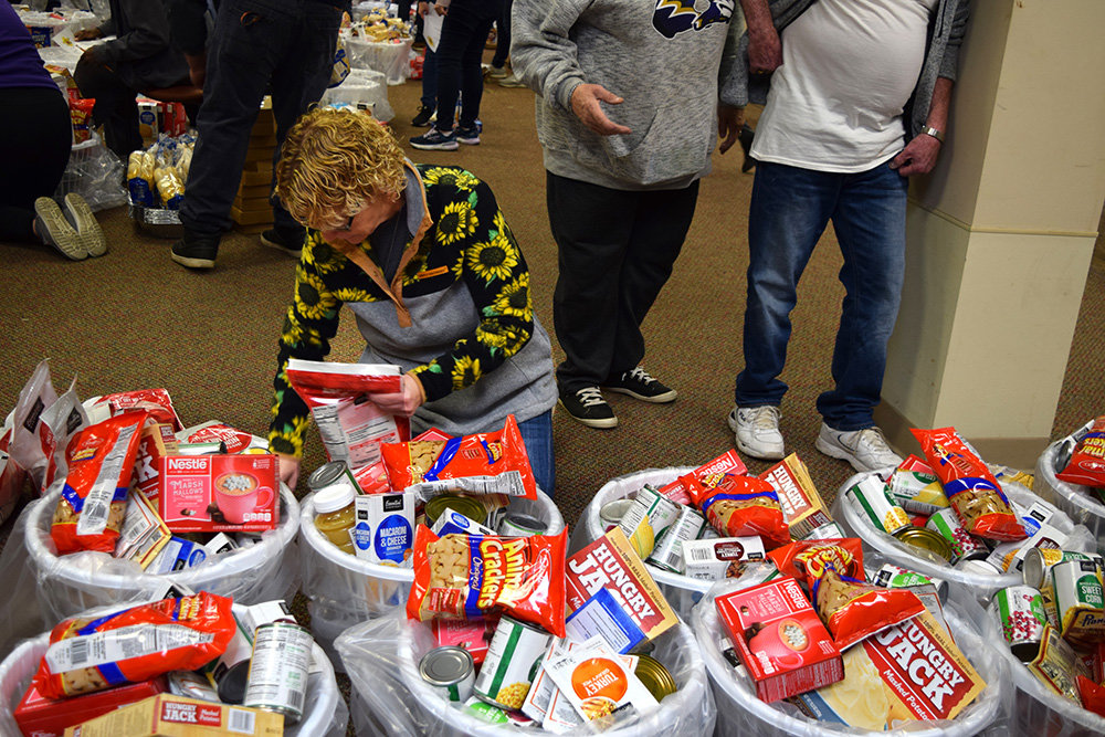 Volunteers sorted items for 150 baskets during Thanksgiving.