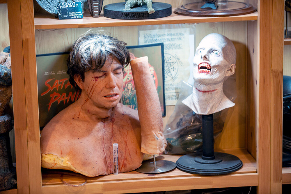 One shelf features a bust of Jerry O’Connell from “Satanic Panic,” a prosthetic arm and blood tube from “The Shape of Water,” and a bust of Lestat from the preproduction of “Interview with the Vampire.”