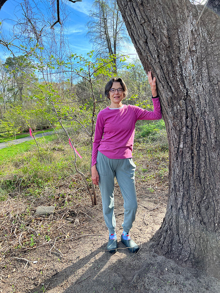 Andrea Weir stood by a mature tree after vine removal.
